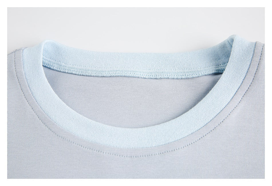 Close-up of a pale blue top's ribbed crew neckline and inner stitching.