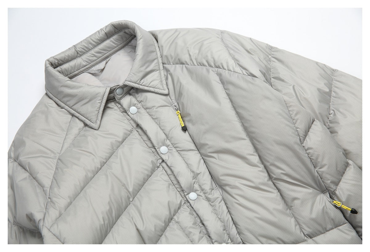 Close view of the gray pinstriped puffer jacket's collar, snap-button placket, quilting, and yellow zipper pulls.