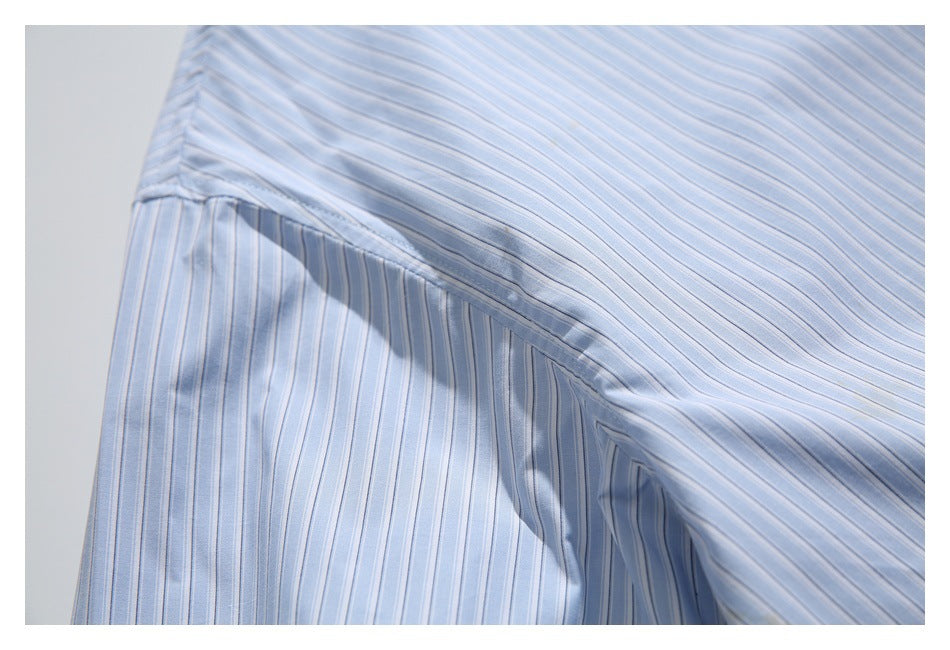 Close-up of the light blue pinstriped shirt’s side seam and underarm construction.