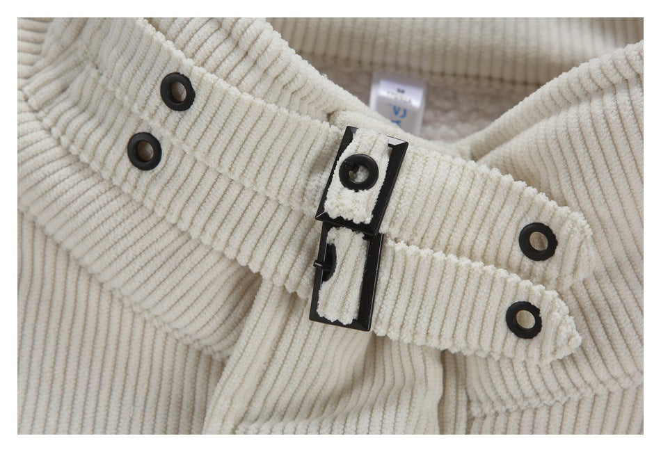 Close-up of black buckle hardware and eyelets on ivory ribbed fabric.