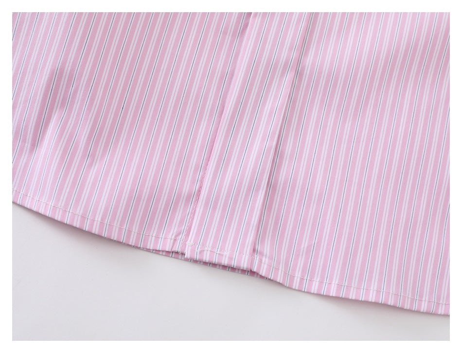 Close-up of the curved hem on a pink-and-white vertically striped garment, with visible stitching.