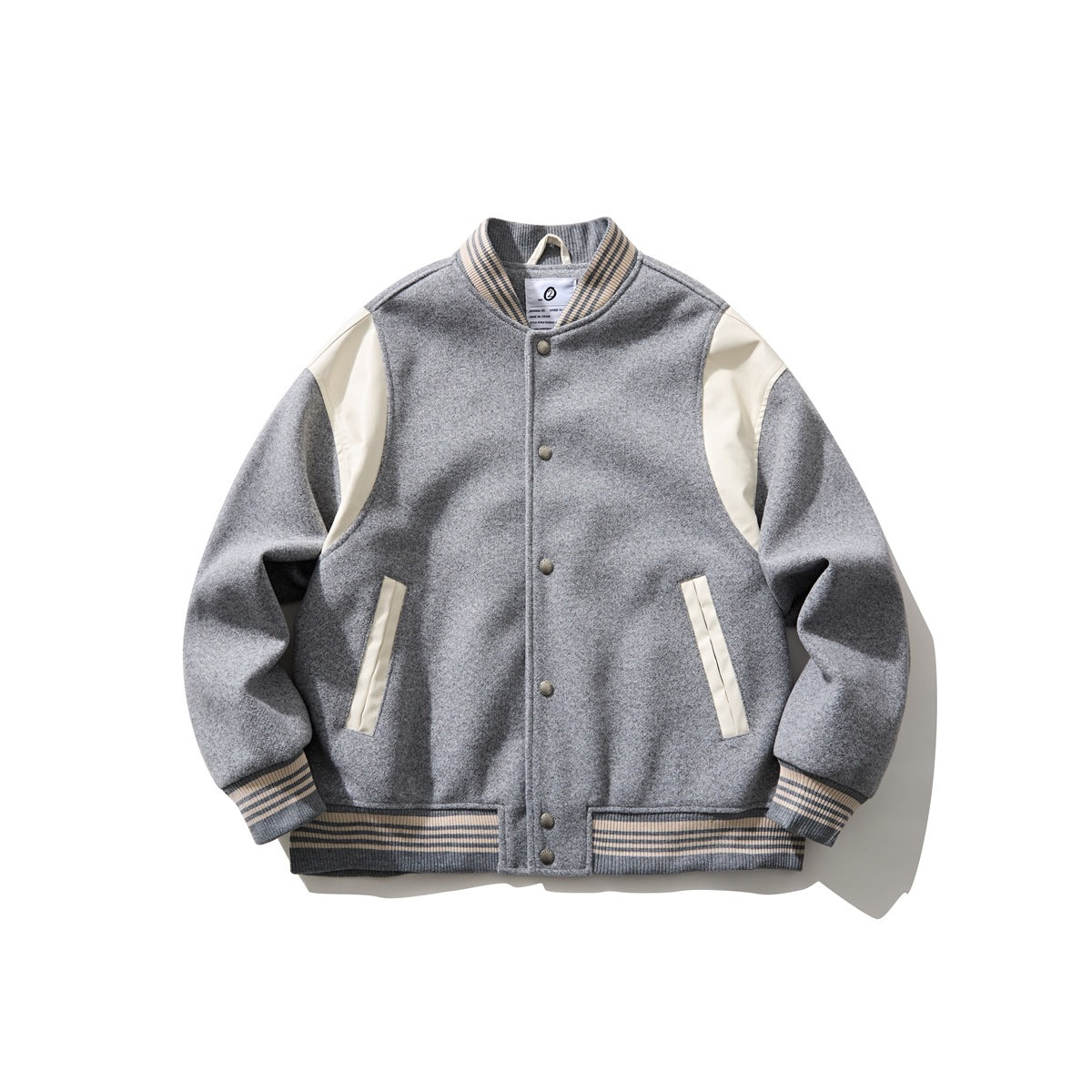 Gray varsity baseball jacket with cream shoulder panels, striped ribbed trim and snap-button front, flat view