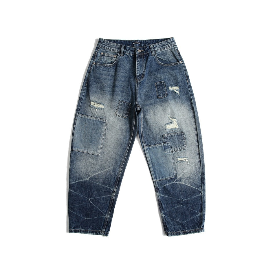 Blue washed wide-leg jeans with patchwork panels and distressed rips, flat lay front view