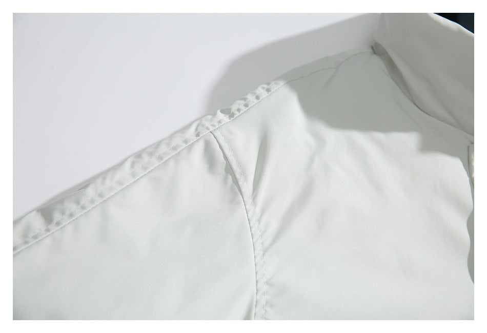 Close-up of the white jacket's shoulder seam and stitched panel construction.