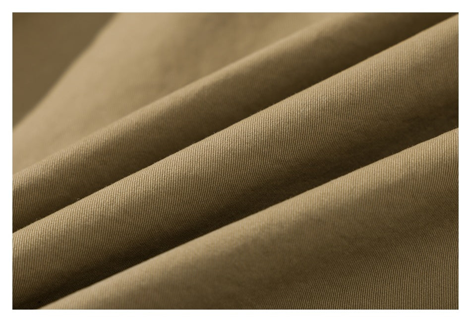Close-up showing the fine diagonal weave and folds of tan garment fabric.