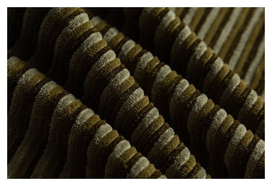 Macro view of the raised olive, tan, and cream stripes in the corduroy fabric.
