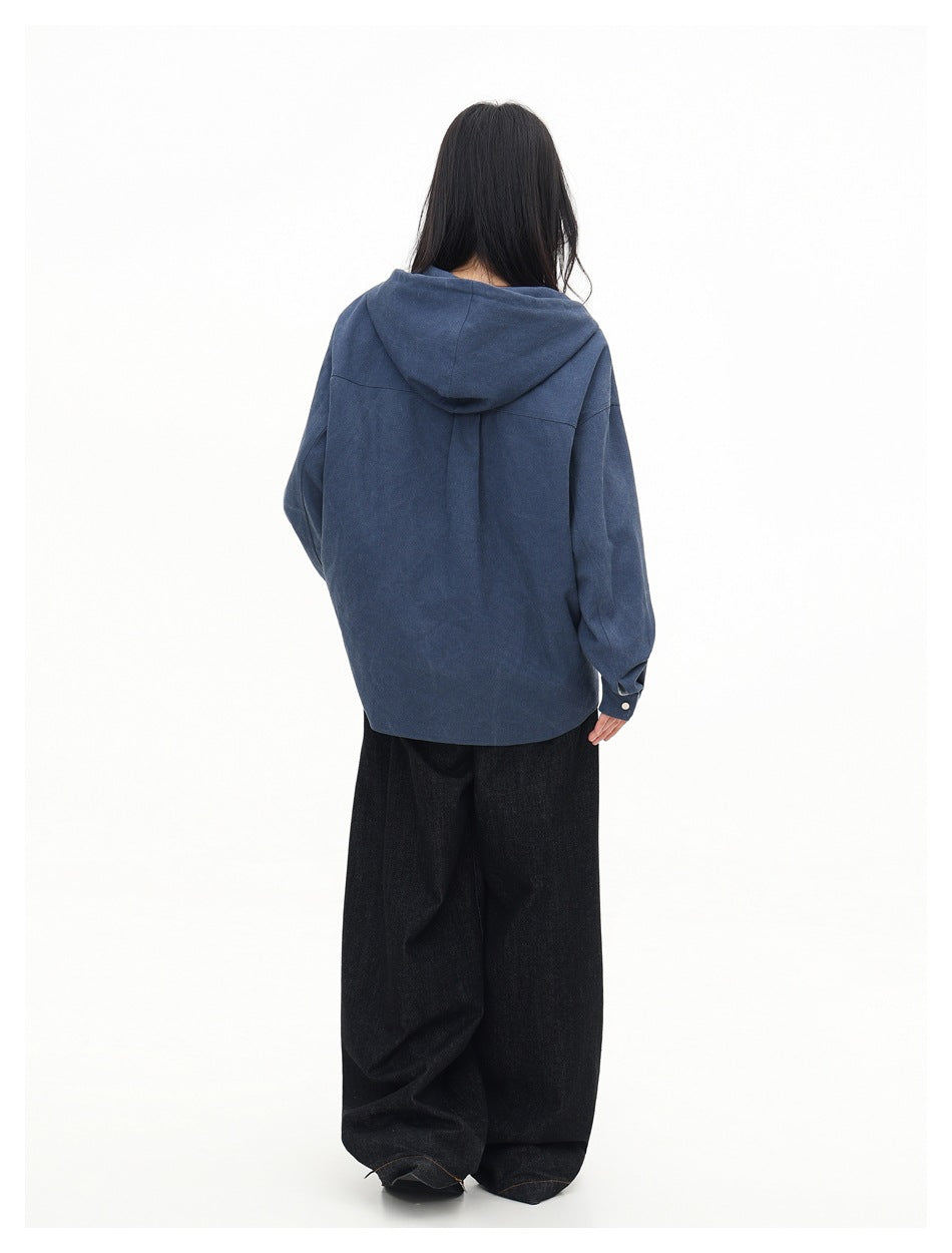 Back view of a model wearing a dark blue hooded overshirt with a plain back.
