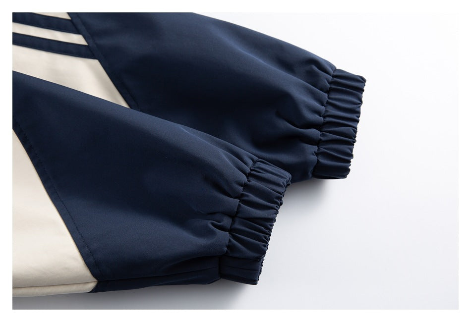 Close-up of two navy jacket sleeves with gathered elastic cuffs and cream panels.