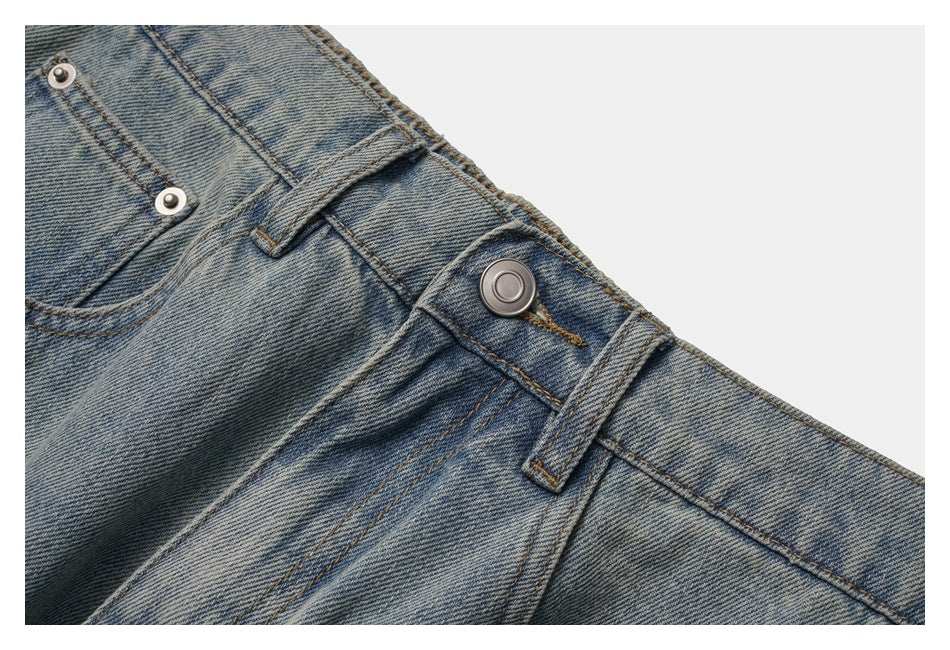 Close-up of the jeans' metal waist button, belt loop, fly stitching, and front pocket edge.