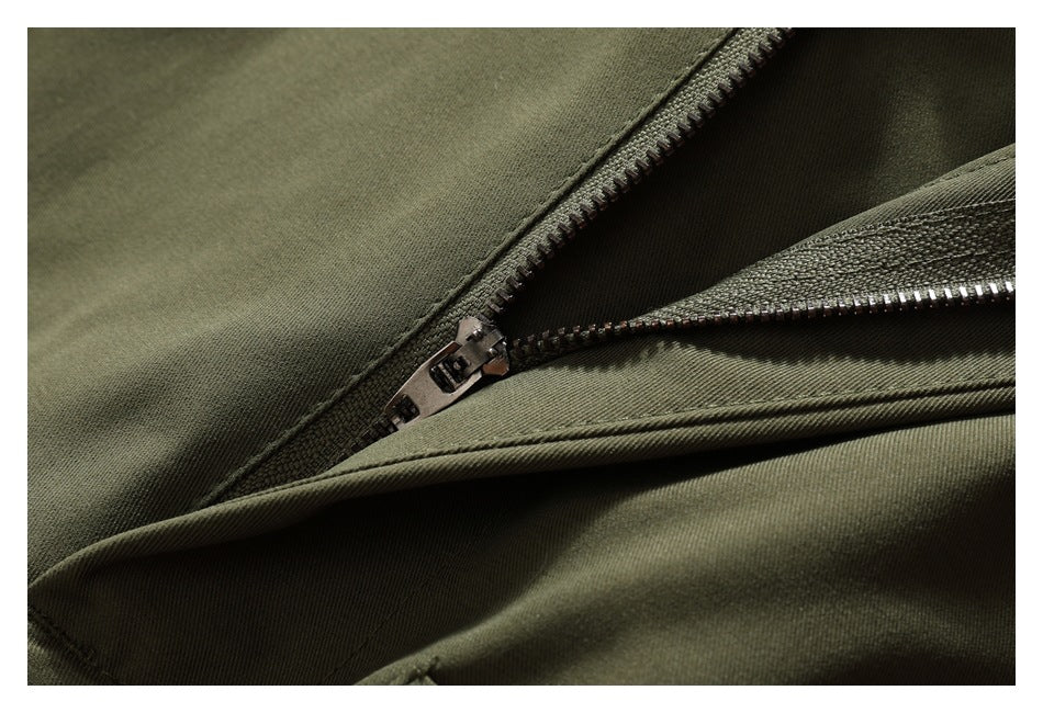 Close-up of olive-green trousers with the fly zipper partly open.