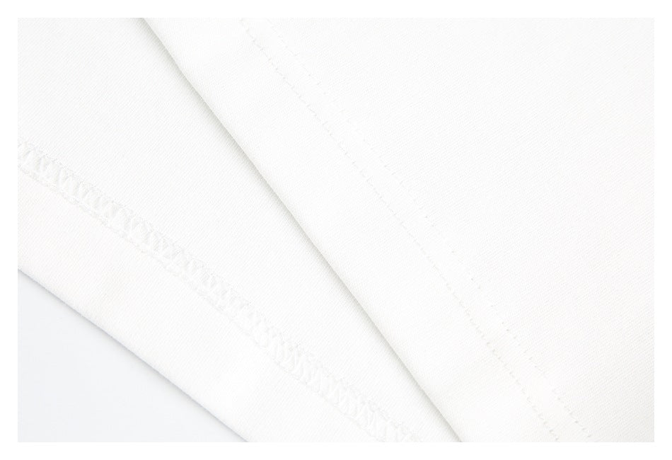 Close-up of white garment fabric showing a folded edge and visible stitching.