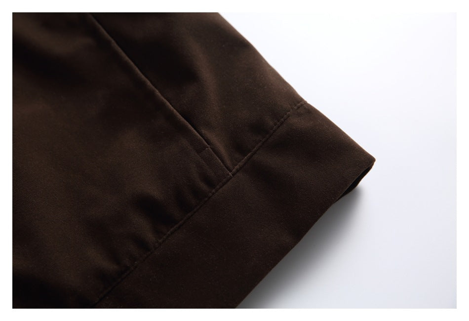 Close-up of a dark brown garment edge with a wide folded band and visible stitching.