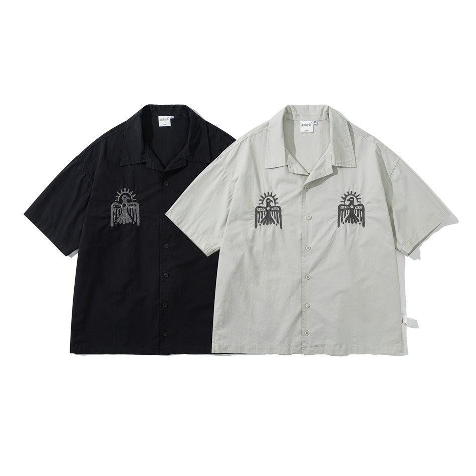 Black and pale gray short-sleeve collared button-up shirts shown from the front; both have dark chest embroidery.