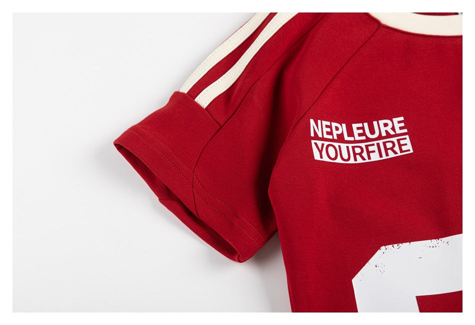 Close-up of a red shirt with cream shoulder stripes and white English lettering on the chest.