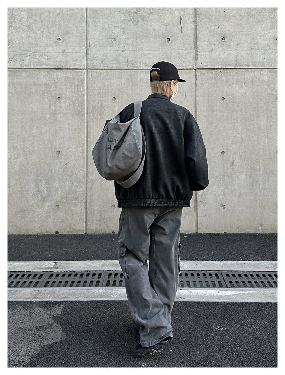Rear view of a model wearing a dark charcoal jacket and gray cargo pants.