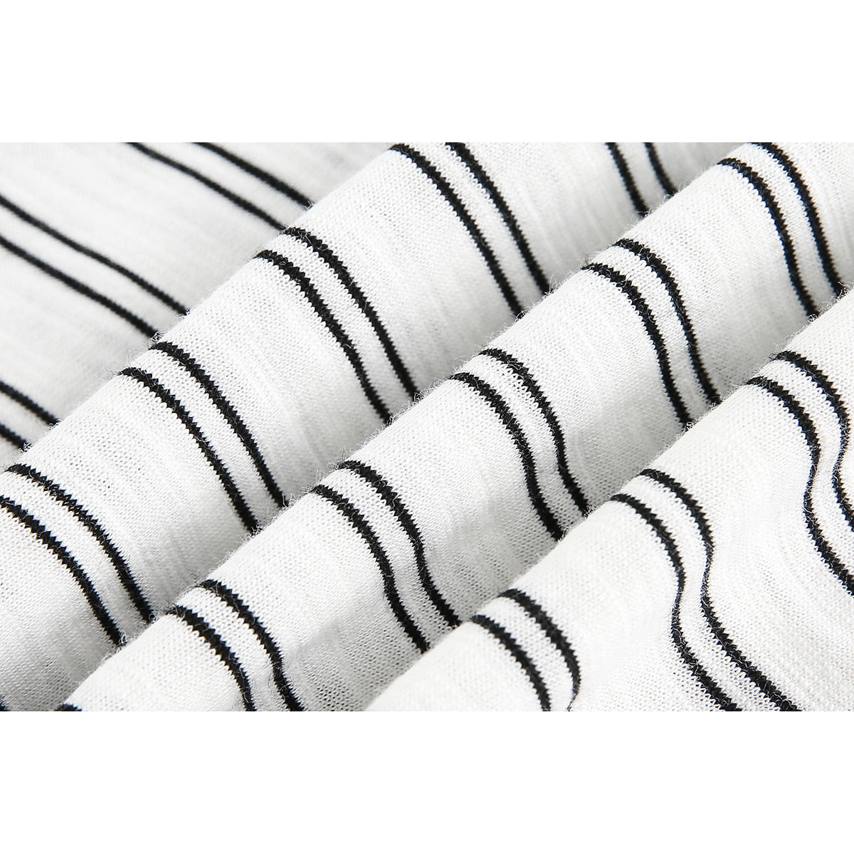Macro view of white knit fabric with narrow black stripes and soft folds.