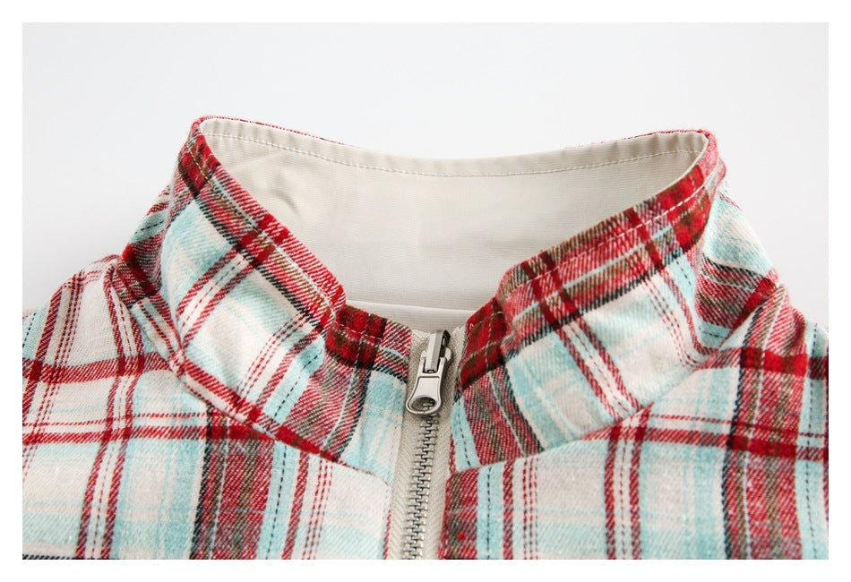 Close-up of a red, aqua, and cream plaid collar with a front zipper.