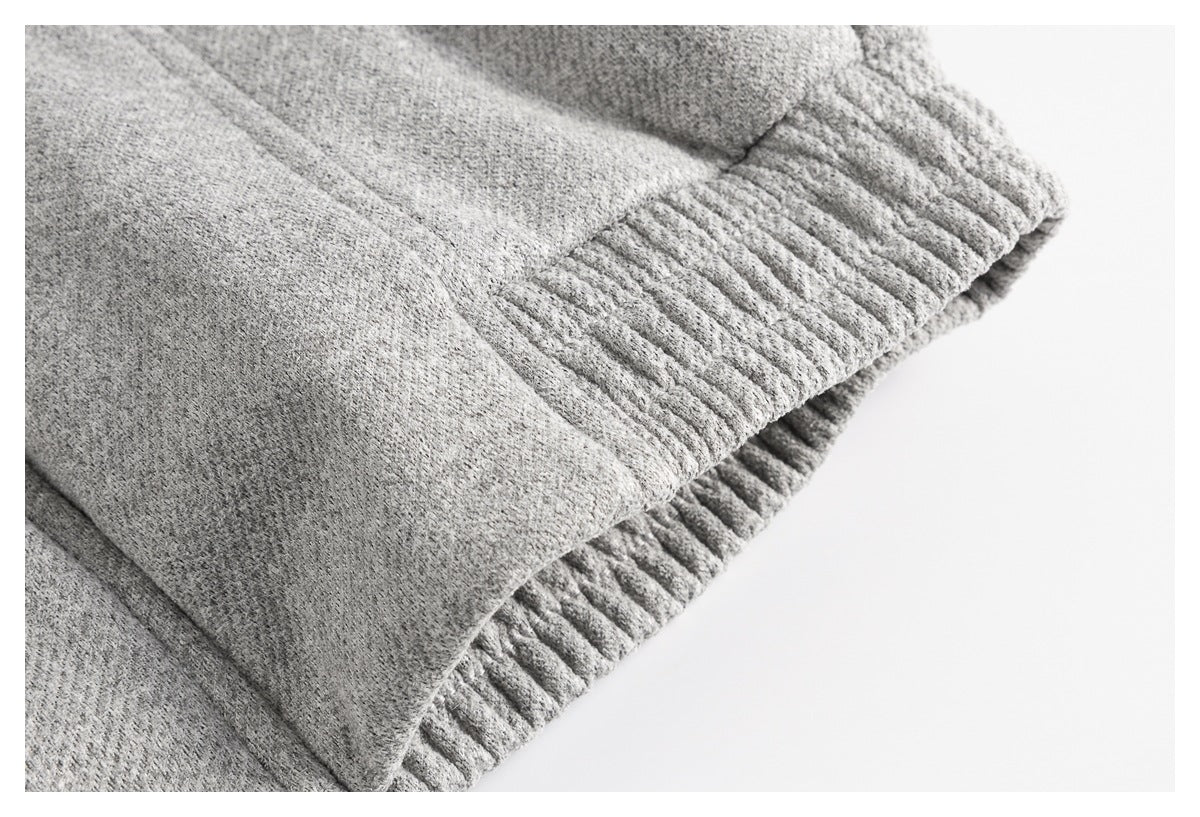 Close-up of a gray coat's gathered ribbed edge and seam.