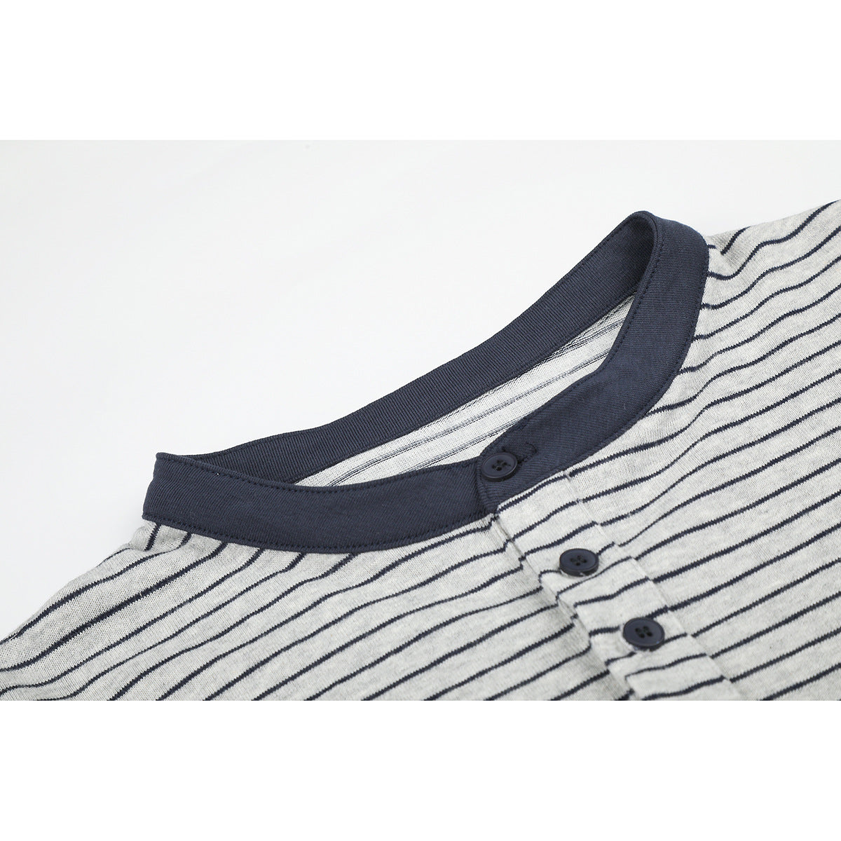 Close-up of a gray striped henley shirt's navy ribbed collar and three-button placket.