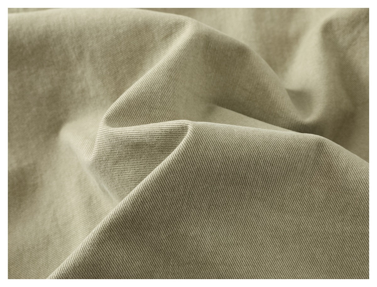 Close-up of muted khaki fabric showing its diagonal twill weave and soft folds.