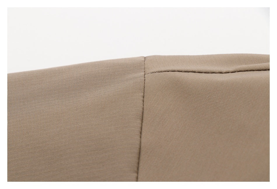 Close-up of a tan garment seam and folded edge.