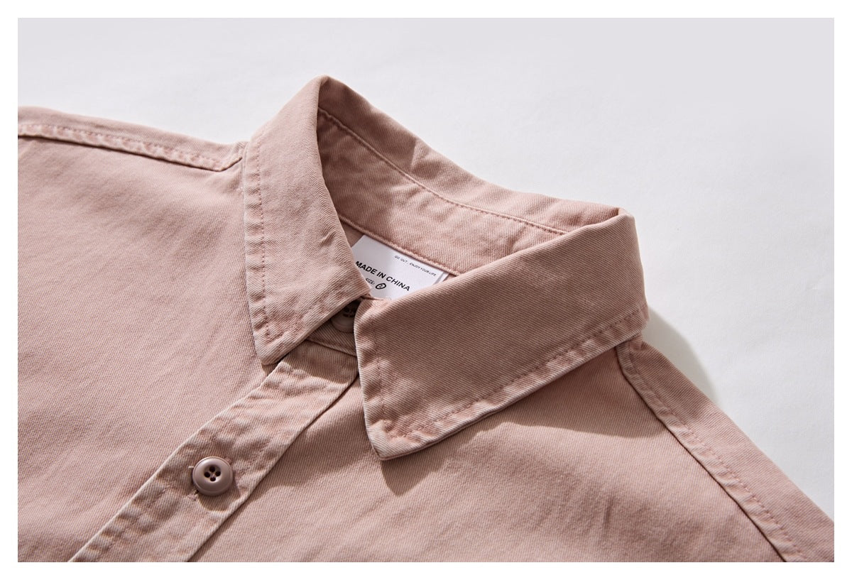Close-up of a dusty rose button-up shirt collar, placket, and inner neck label.