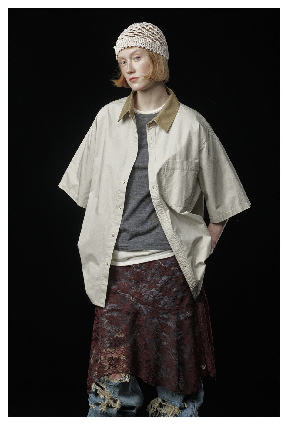 Closer front view of a model wearing an oversized cream shirt with a contrasting tan collar and chest pocket.