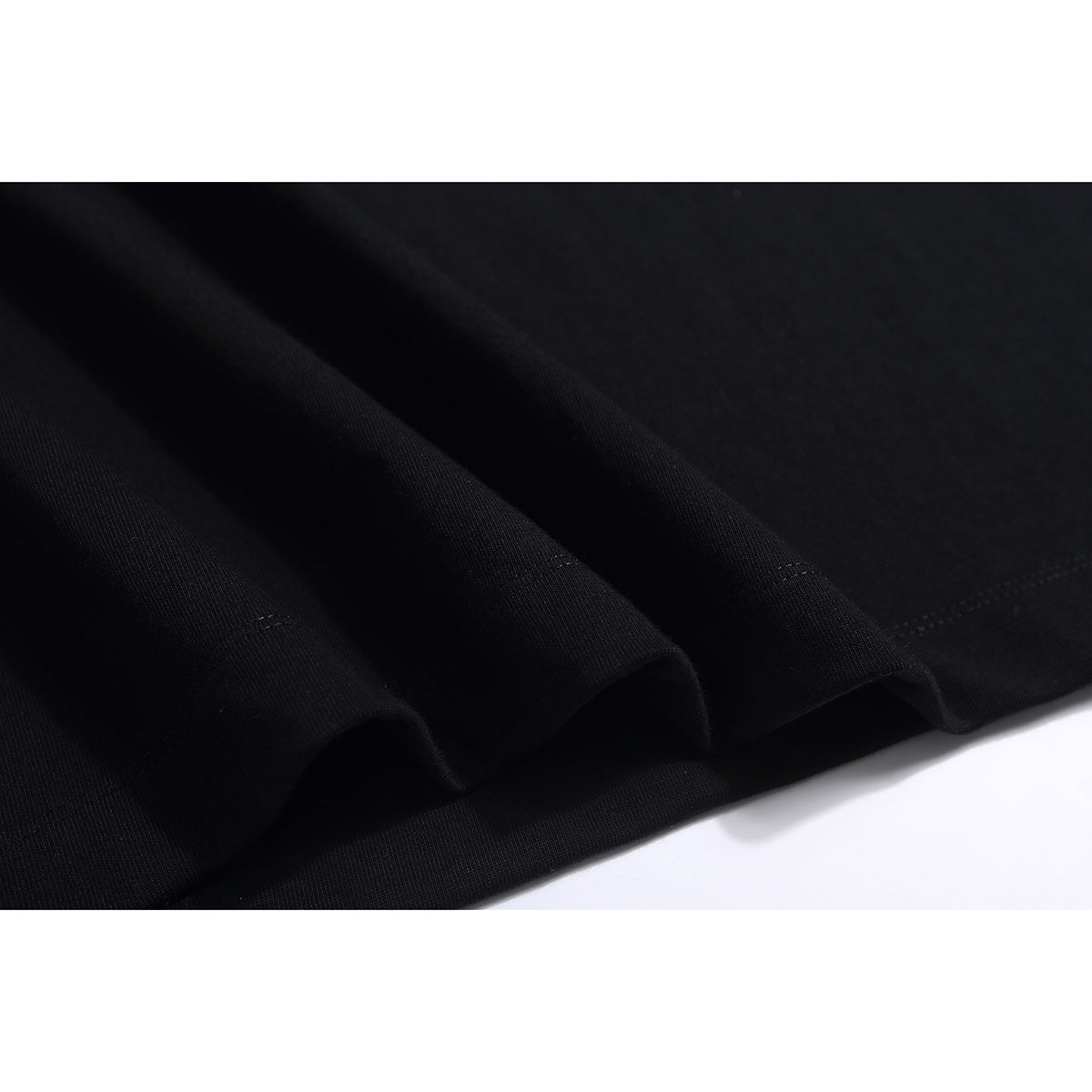 Close-up of the black T-shirt’s folded hem and stitching.
