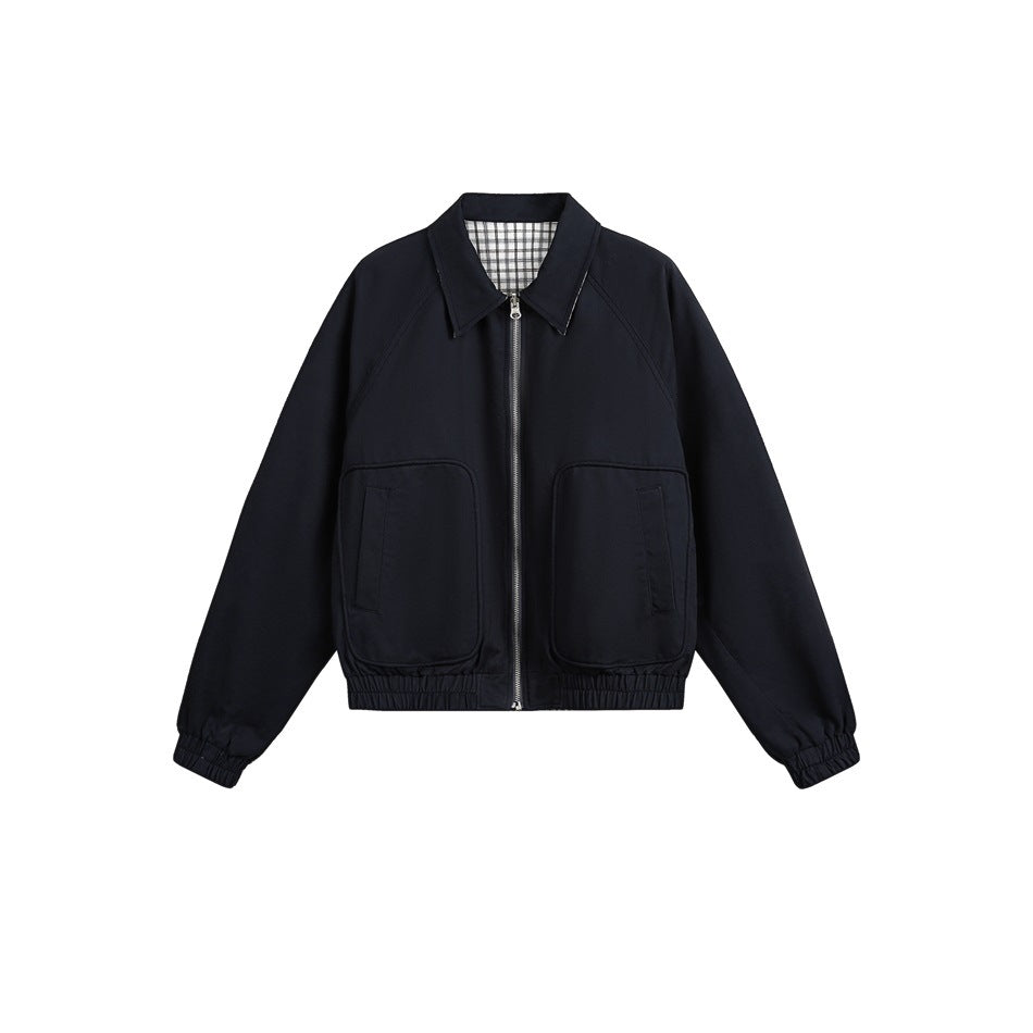 Front view of a dark navy zip-up jacket with a pointed collar, plaid inner lining, two patch pockets, and gathered cuffs and