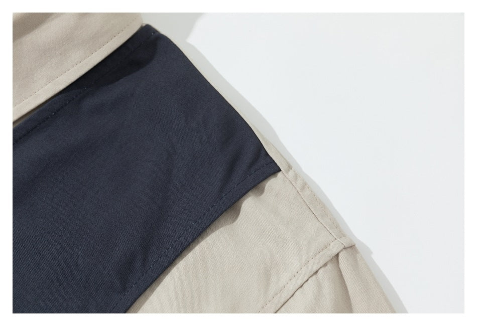 Close-up of a dark navy panel joined to beige fabric with visible stitching.