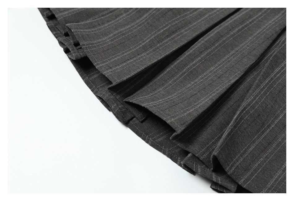 Close-up of overlapping folded edges on a charcoal garment with narrow light pinstripes.