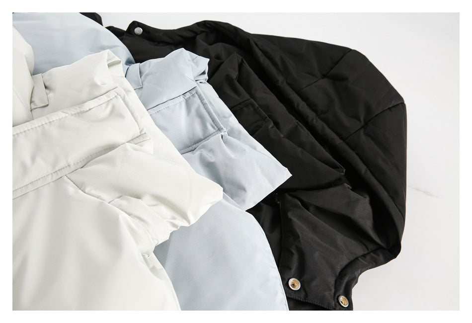 Black, pale blue-gray, and off-white hooded jackets overlap in a close-up flat lay.