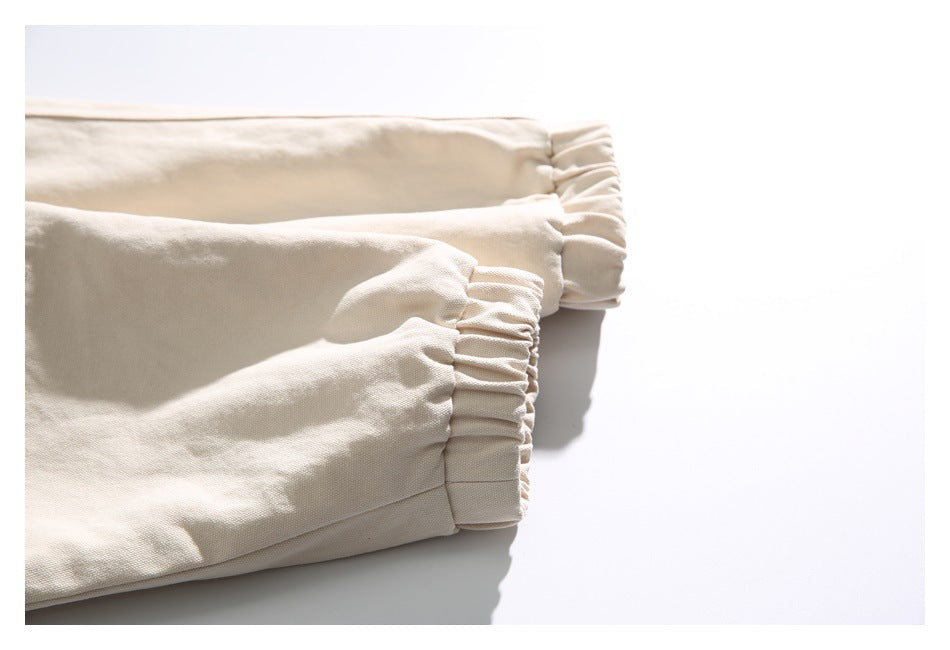 Close-up of a light beige jacket sleeve with gathered elastic cuffs.