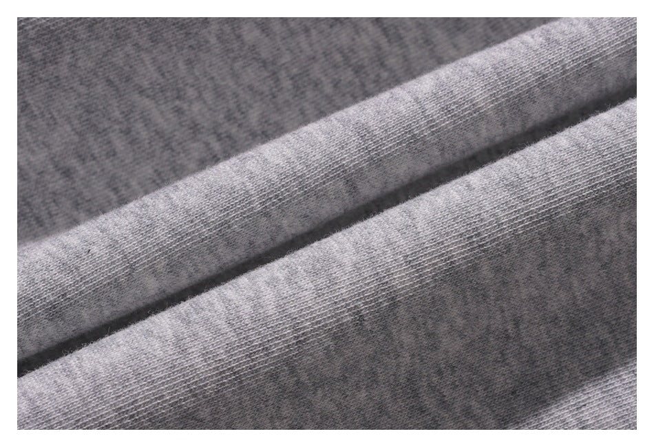 Close-up of heather gray knit fabric arranged in soft folds, showing its textured surface.