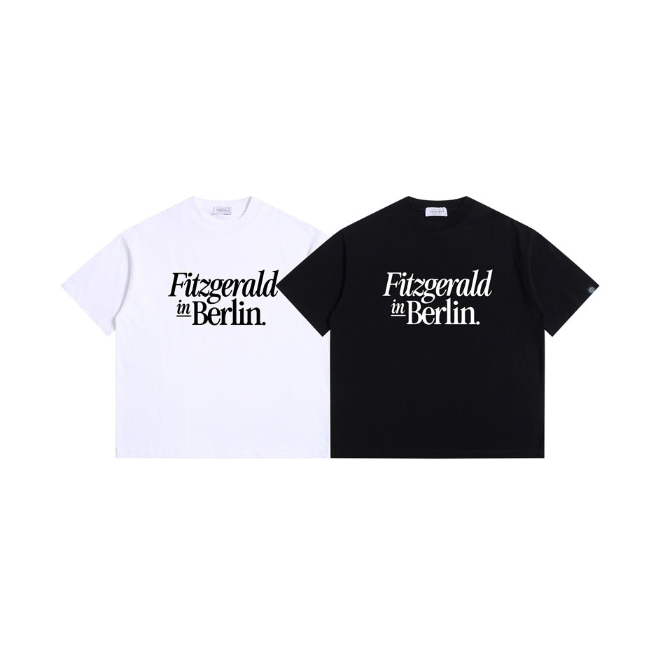 White and black short-sleeve crew-neck T-shirts shown from the front, each printed with “Fitzgerald in Berlin.”