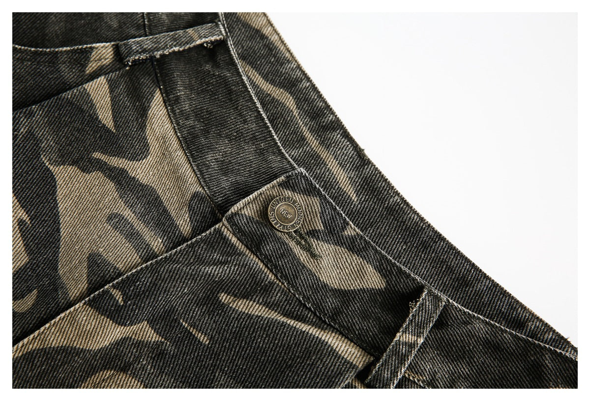 Close-up of a button and belt loop on the waistband of dark camouflage shorts.