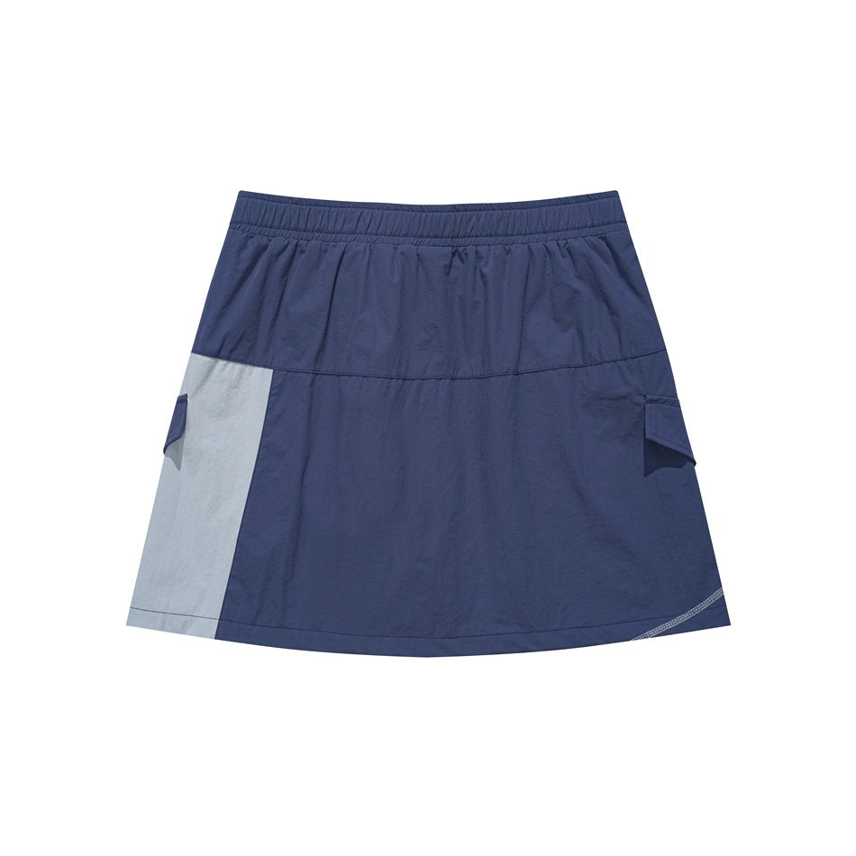 Back view of a navy mini skirt with an elastic waistband, pale gray side panel, and flap pockets.