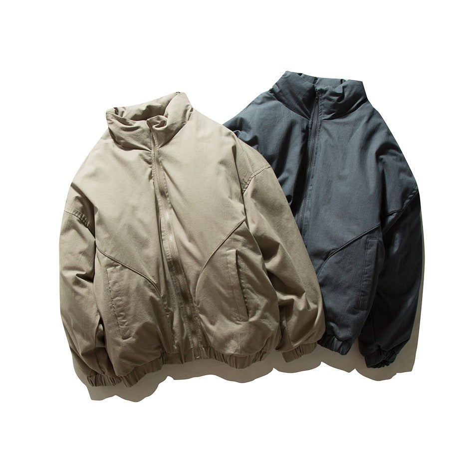 Two zip-front jackets with stand collars and elastic hems, shown in beige and dark blue-gray.