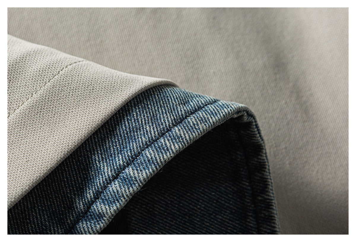Close-up of taupe-gray fabric folded over a dark blue textured edge, showing the contrasting surfaces and weave.