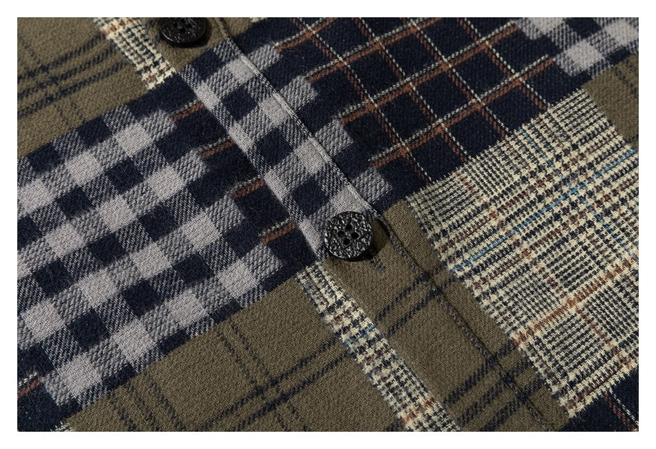 Close-up of a black button and placket on an olive, navy, gray, and cream plaid shirt.