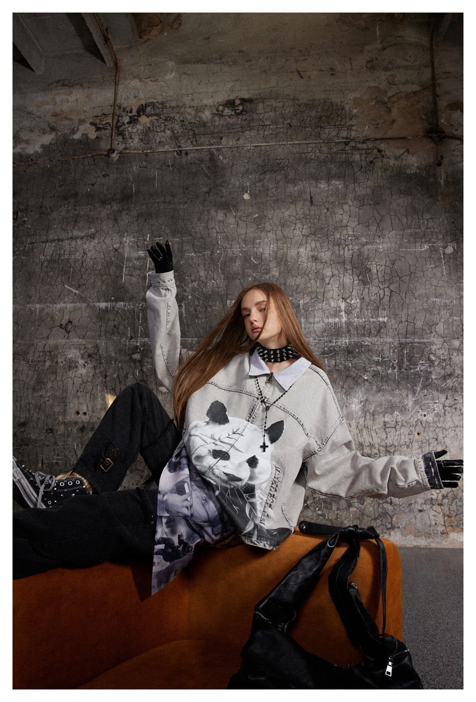 Model lounging in an oversized pale gray panda-print jacket with black trousers and a purple graphic layer.