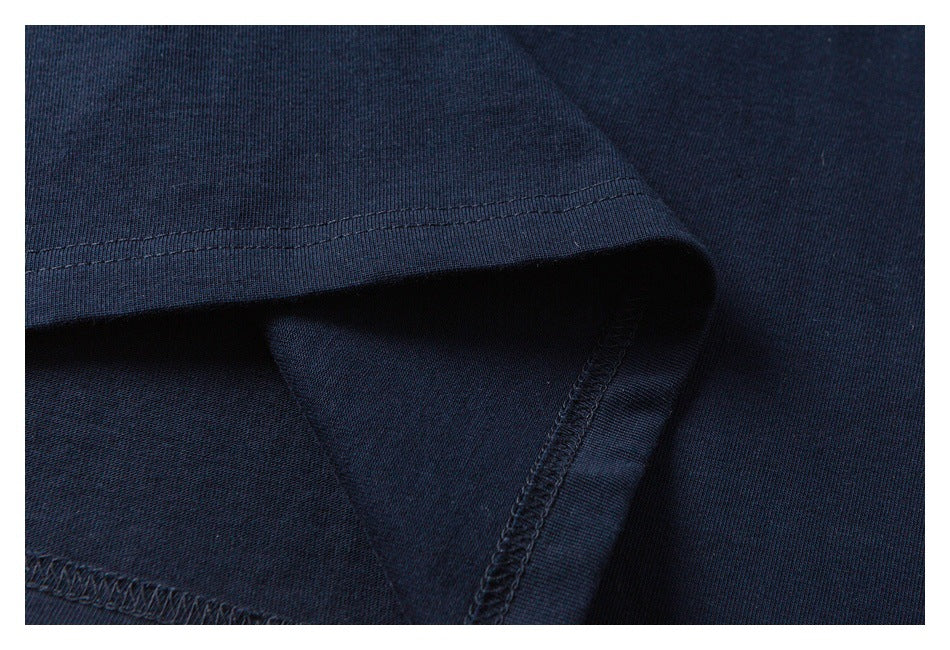 Close-up of dark navy knit fabric showing a folded hem and stitched seam.