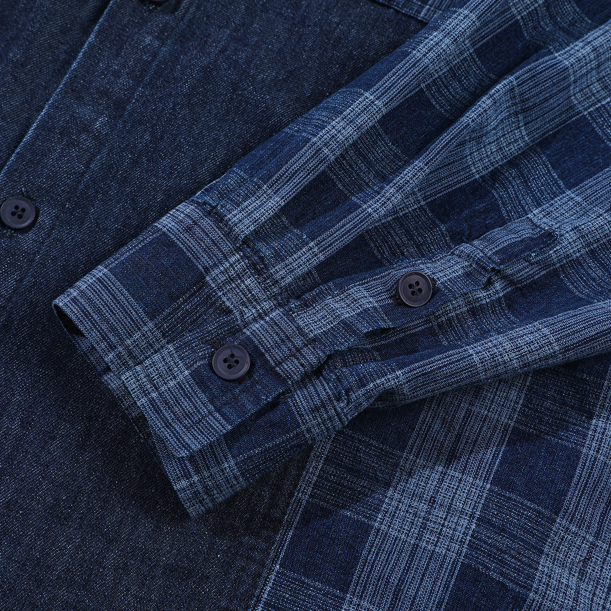 Close-up of a dark navy shirt with a blue plaid sleeve and dark buttons.