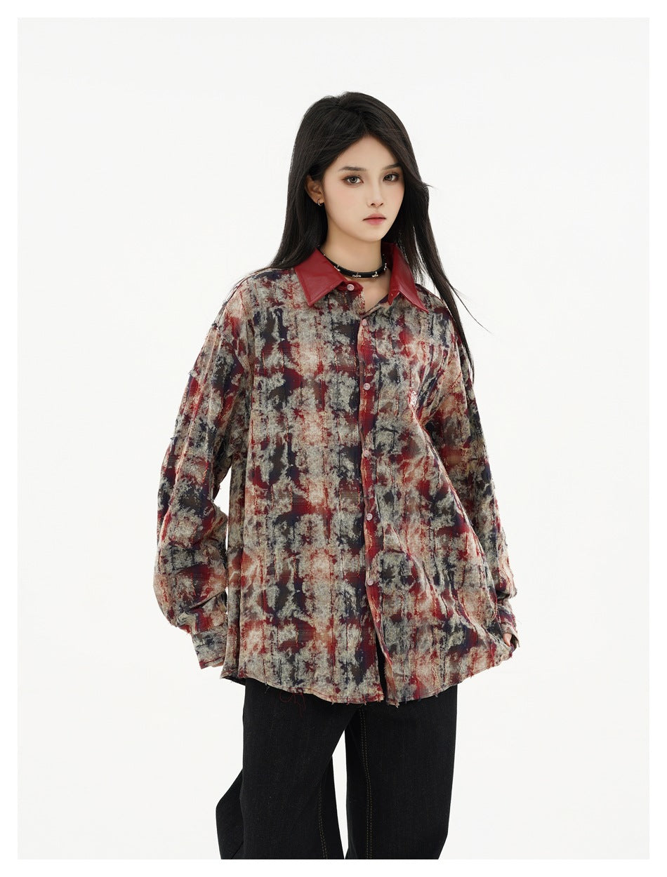 Model wearing a loose burgundy, charcoal, and beige abstract-print button-up shirt with a dark red collar.