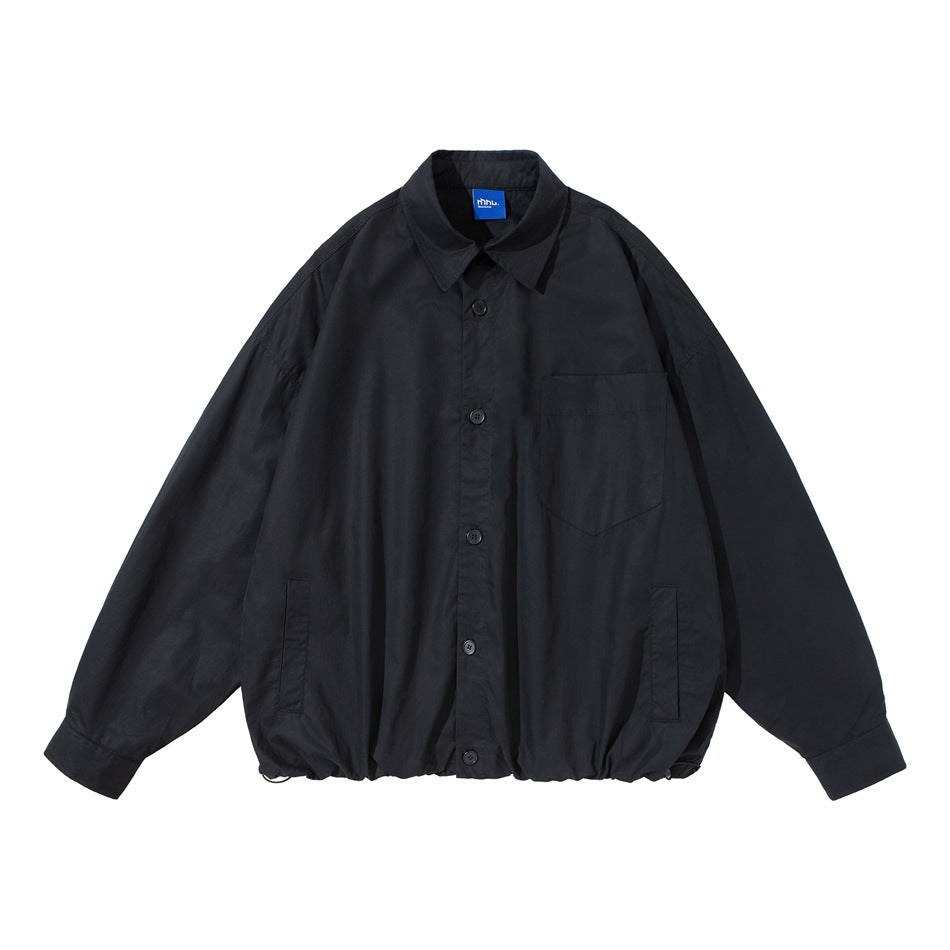 Black button-front shirt-style jacket flat lay with chest pocket, slit pockets and drawstring hem