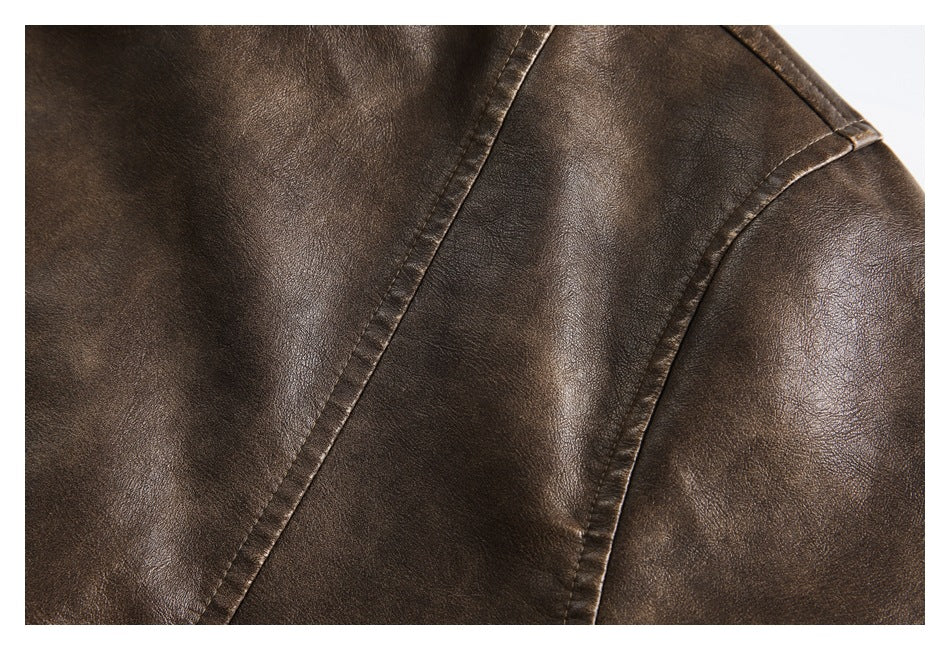 Close-up of a brown jacket's textured surface and curved stitched panel seams.