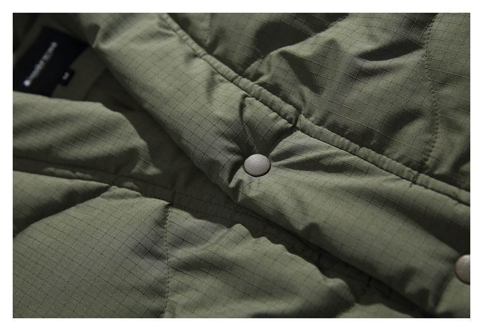 Close-up of a snap on the jacket's olive quilted front placket and ripstop fabric.