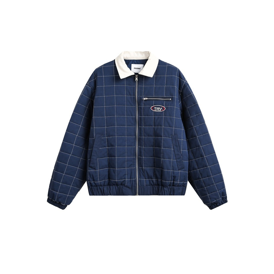 Blue quilted zip jacket with grid stitching, cream collar, chest zip pocket and oval patch, flat front view