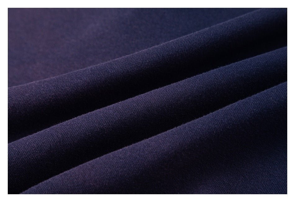 Extreme close-up of dark navy fabric gathered into soft folds.