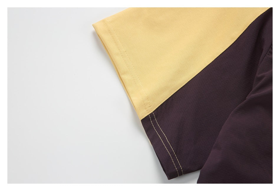 Close-up of the sleeve hem on a top with pale yellow and dark contrasting panels.